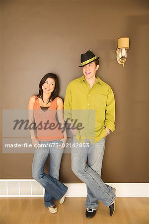 Young couple leaning on wall