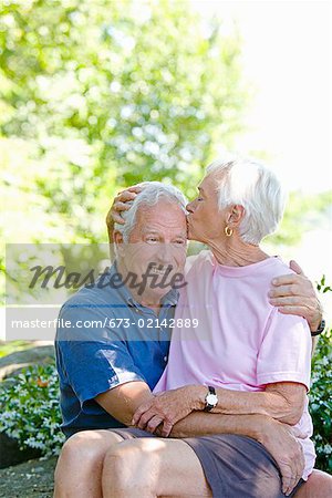 Senior woman kissing husband on head