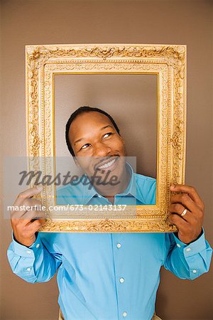 African man looking through picture frame