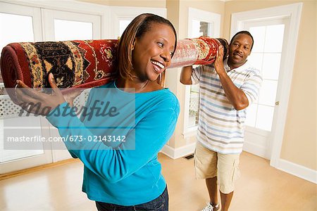 African couple carrying rug