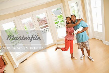 African couple hugging in new house