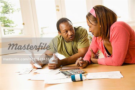 African couple paying bills in new house
