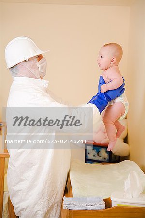 Father in decontamination suit holding baby