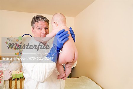 Father in decontamination suit holding baby