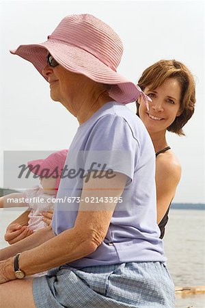 Grandmother and mother with baby at beach