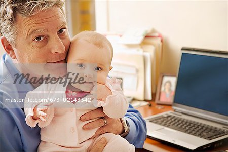 Businessman holding baby