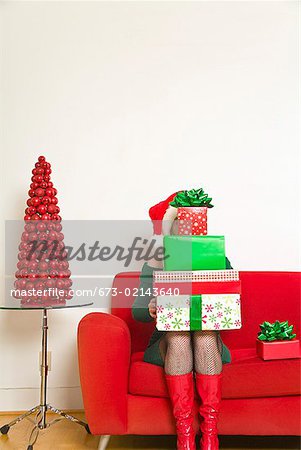 Frau sitzt mit Stack für Weihnachtsgeschenke