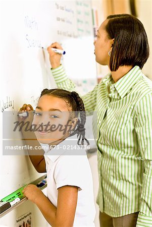 African teacher and student writing on whiteboard