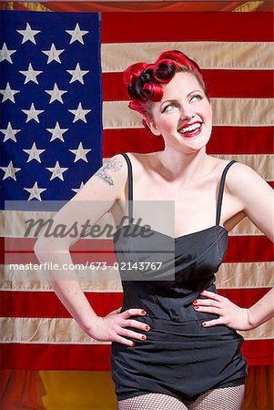 Femme avec mains sur les hanches devant le drapeau américain