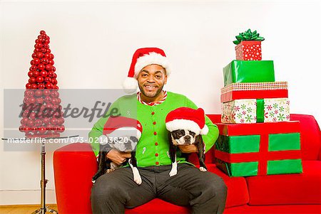 Afrikanische Menschen und Hunde tragen Nikolausmützen