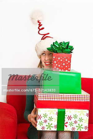 Femme tenant la pile de cadeaux de Noël