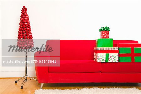 Stack of Christmas gifts on sofa