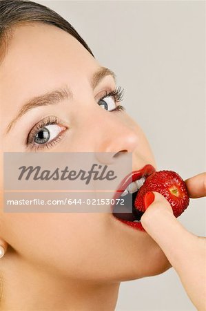Femelle jeune adulte mange une fraise