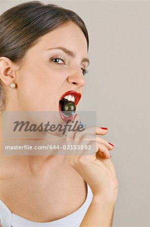 Female young adult biting a lollipop