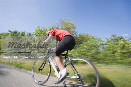 Side view of a cyclist cycling on road, blurred motion