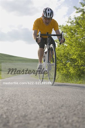 Front view of a man cycling on road