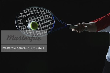 Tennis Player Swinging at Ball