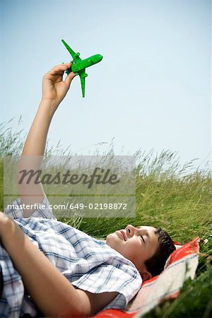 Boy lying down playing with plane