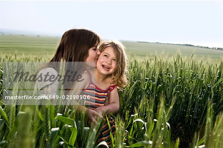 Mère enfant baiser dans le champ de blé