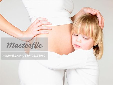Girl holding her mother's pregnant belly