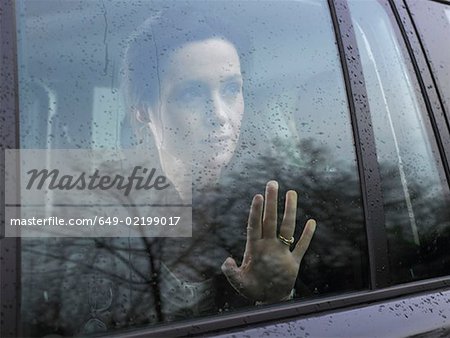 Femme regardant par la fenêtre de la voiture