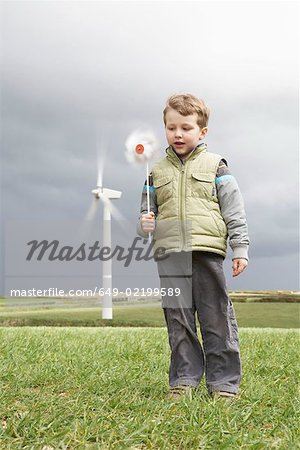 Garçon avec moulin à vent sur une ferme éolienne