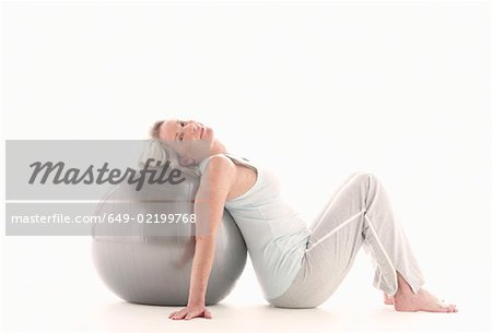 Mature woman lying on exercise ball