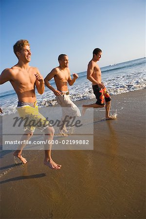 Three Teenage Boys Running on Beach