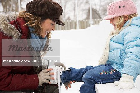 Mother Helping Daughter Put on Ice Skates