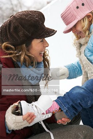 Mother Helping Daughter Put on Ice Skates