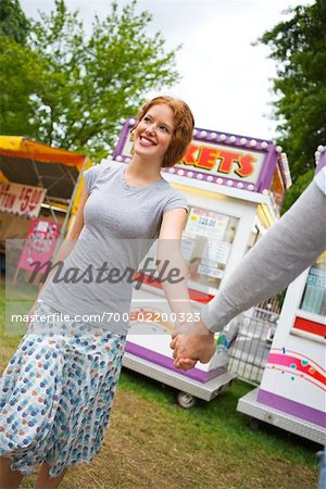 Teenager Mädchen und jungen, die Hand in Hand zu einem Karneval