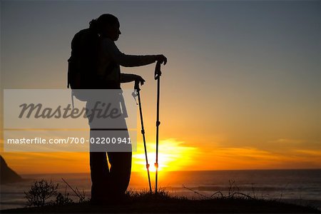 Randonneuse sur une falaise surplombant l'océan au coucher du soleil, Palos Verdes, Californie