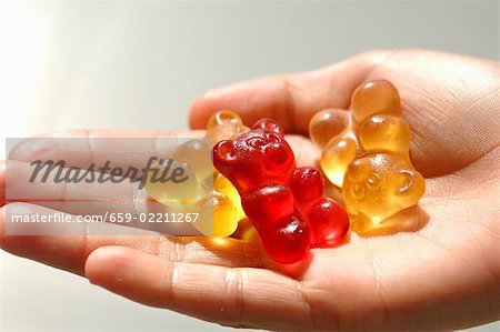 Three gummi bears in someone's hand