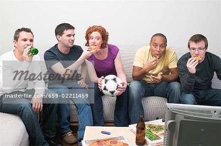 Freunde sitzen vor Fernseher mit Fußball, Pizza & Bier