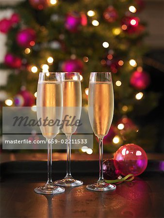 Trois verres de champagne, arbre de Noël en arrière-plan