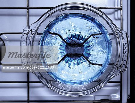 Bubbling water in a glass pan on a gas flame