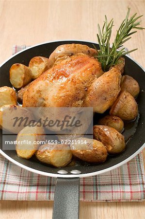 Chicken with roast potatoes in a frying pan