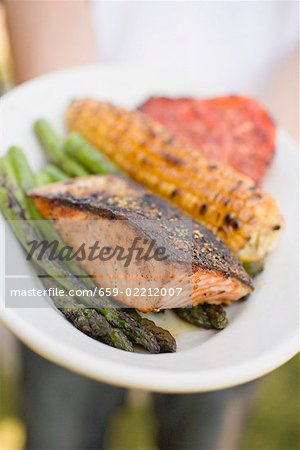 Plaque de maintien personne de saumon grillé, maïs en épi, légumes