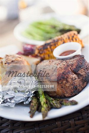 Grilled beef steak, asparagus, baked potato, corn on the cob Grilled beef steak, asparagus, baked potato, corn on the cob