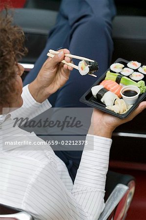 Femme, manger des sushis au bureau