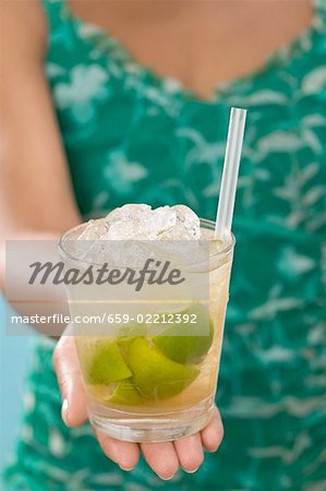 Woman holding glass of Caipirinha