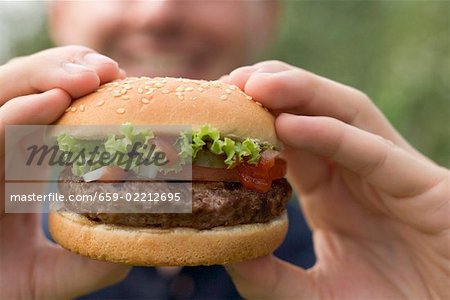 Man holding large hamburger