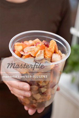 Woman holding vegetable dish in plastic tub