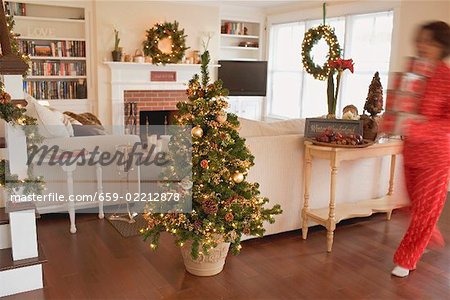 Woman carrying boxes of Christmas decorations into living room