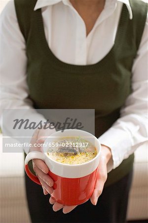 Woman holding cup of mushroom sauce