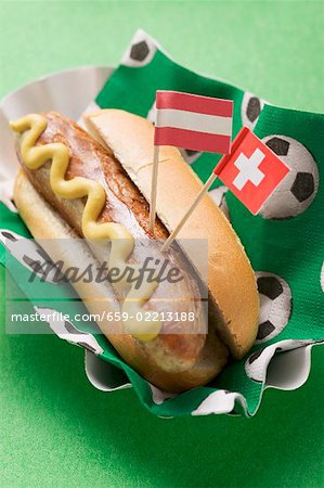 Hot dog with mustard & flags on napkin with football motifs