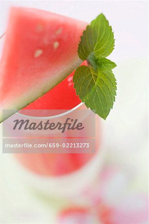 Watermelon drink with wedge of watermelon and mint leaves