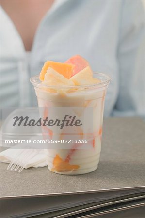 Fruit yoghurt in office, woman in background