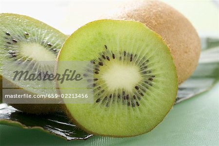 Deux moitiés d'un fruit kiwi devant toute kiwis