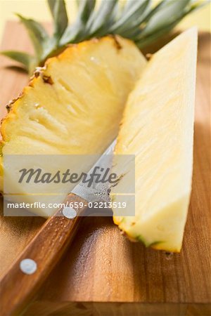 Morceaux d'ananas sur la planche à découper avec couteau